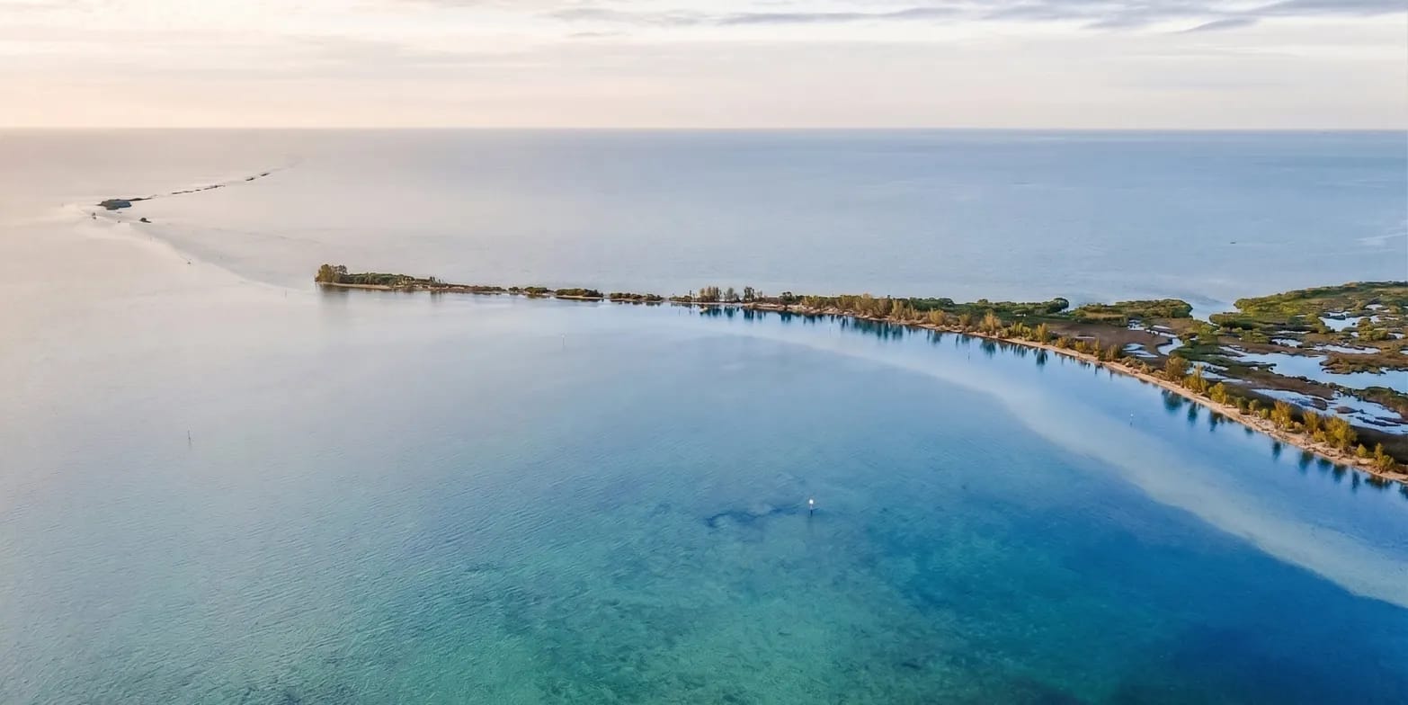 Aerial view of Hernando County's coastline with sandbars and clear water at sunset