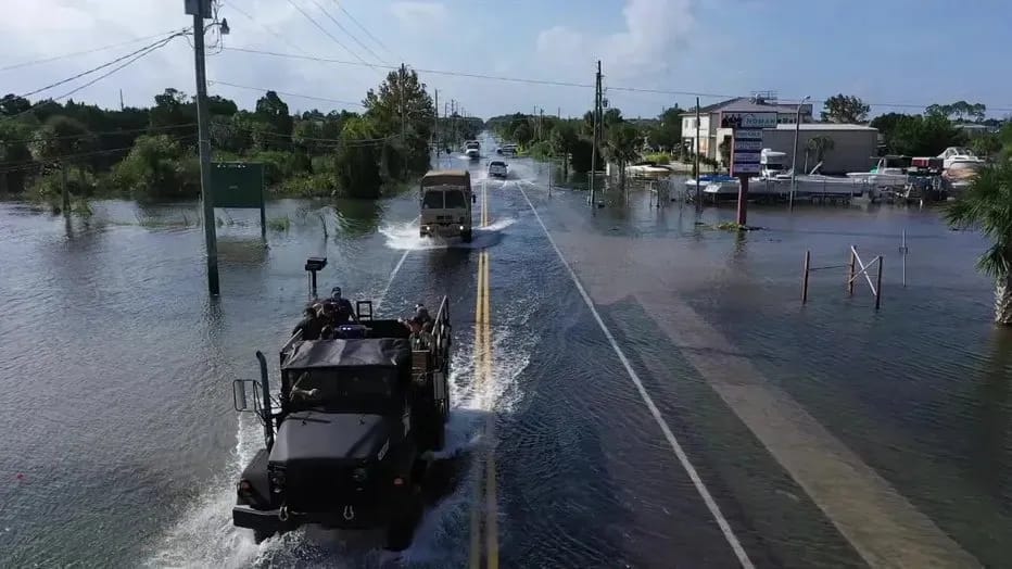 Drone view of military rescue trucks moving through floodwaters on a Hernando County road during the 2024 hurricane response