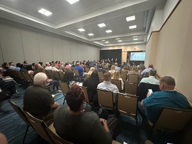 Sabrina Dugan and Omar DePablo presenting on AI-native permitting to a packed conference audience