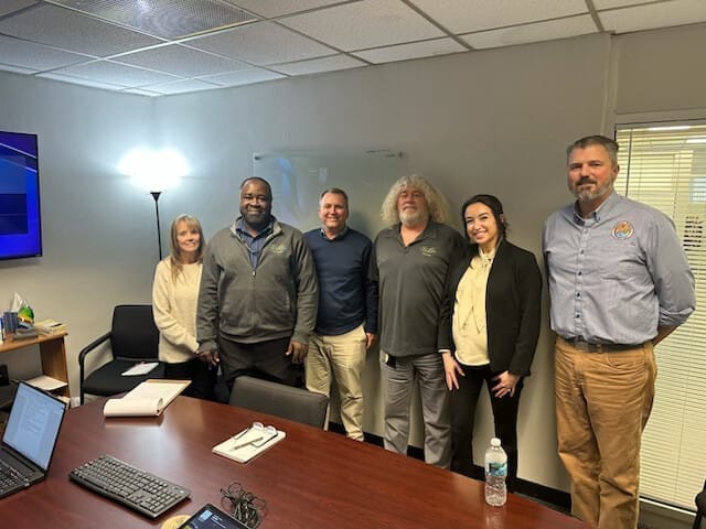 Members of the City of Titusville Development Services team in a meeting room with Swiftbuild founders, including Kwabena Ofosu, Brad Parrish, Mark Jones, Steve Adam, and Sabrina Dugan